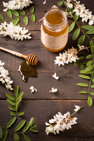 Acacia honey and flowering acacia on wooden tableの写真素材