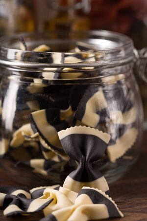 closeup of coloured farfalle in a jarの写真素材