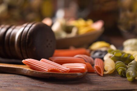 various coloured pasta over wooden backgroundの写真素材