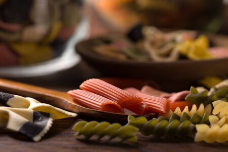 various coloured pasta over wooden backgroundの写真素材