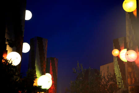 Night time shot of illuminated chinese lantern decarations with plants at the foreground and night sky in the background.の写真素材