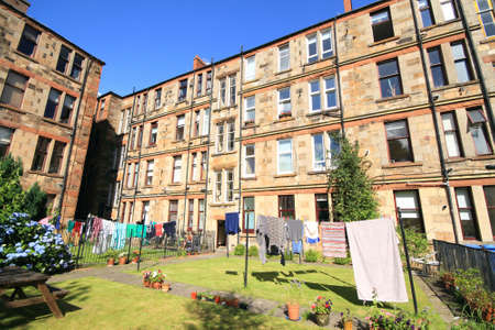 back garden of block of residential tenement flats with washing on the line on a summers day in glasgow, scotland.の写真素材