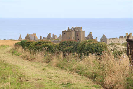 dunnottaar castle ruins, stonehaven, scotland with grass, hedges and the ocean in view.の写真素材