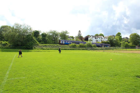 public park with passenger train going past on a summers dayの写真素材
