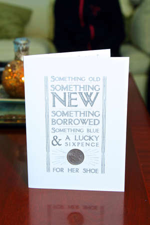 lucky sixpence wedding card on a table complete with real sixpence piece.の写真素材