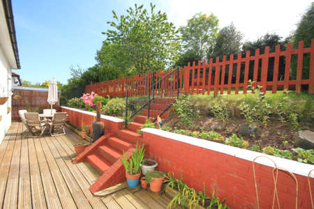 back garden with decking and red wallの写真素材