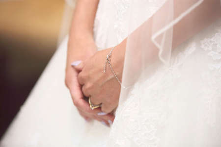 close up of the brides hands before the wedding showing dress, bracelet and ring.の写真素材