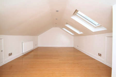 empty attic bedroom with skylight windowsの写真素材