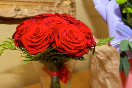 bouquet of bright red roses in a vase at a wedding.の写真素材