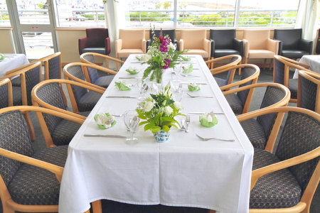 table set up with flowers, glasses, cutlery and napkins with wedding favour for the guests.の写真素材