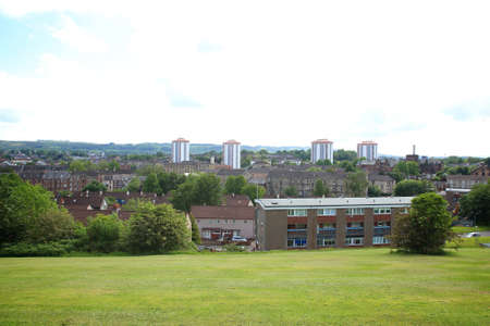 view of the town from the top of the park with grass, buildings, hills and sky in view.の写真素材