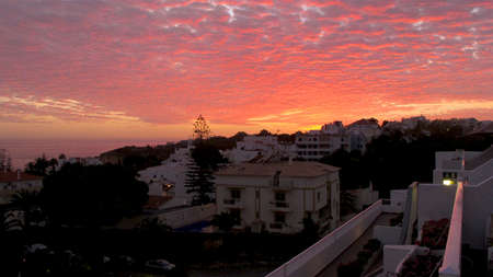 red and yellow sun setting over the hotel resort in the Algarve in Portugal.の写真素材