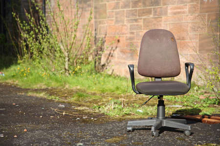 lonesome abandoned old swivel chair in the grounds of an old hospitalの写真素材