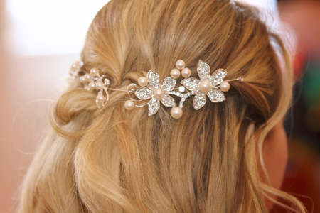 close up the back of a girls hair with flower shaped bridal hair accessories for a wedding.の写真素材