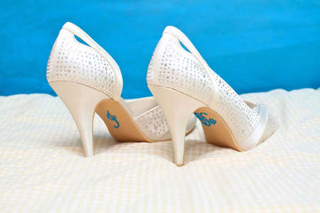 white coloured brides shoes with the words I Do spelled out in diamontes on the soles of the shoes.の写真素材