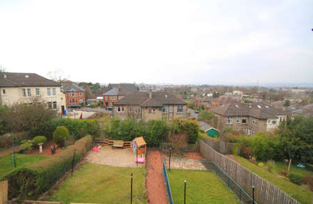 view of residential gardens with grass, houses, fences and houses in view.の写真素材