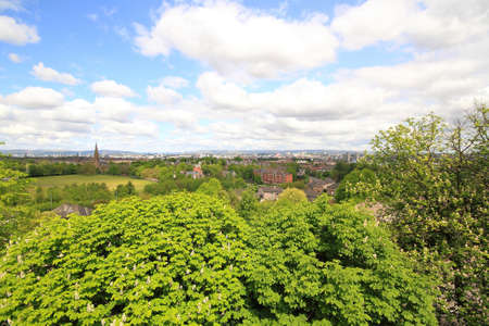 panoramic view from the veranda with trees, grass and houses in the distance with blue skies and fluffy white clouds.の写真素材