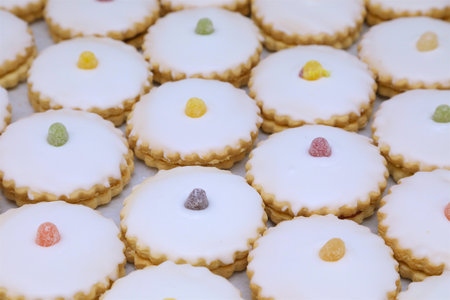 selection of jam tarts side by side on a baking tray with jelly tots on the centreの写真素材