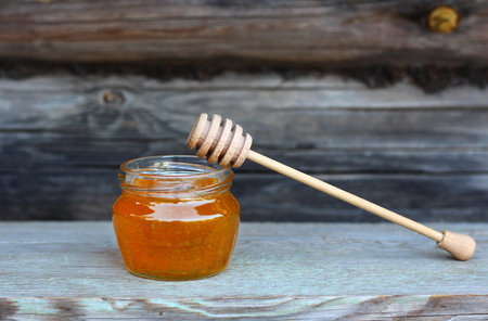 a jar of honey on wooden backgroundの写真素材