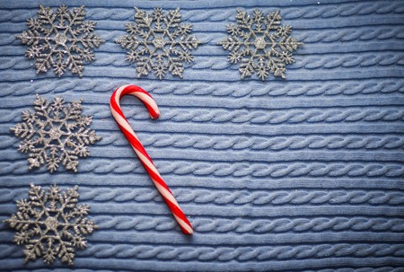 Christmas candy with snowflakes on blue fabric background with copy spaceの写真素材