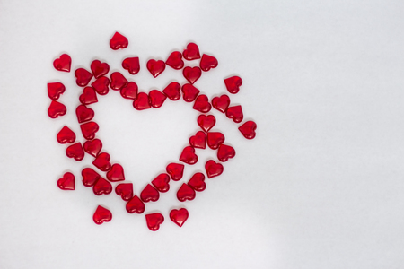 Valentine's day greeting card scattered red hearts on white backgroundの写真素材