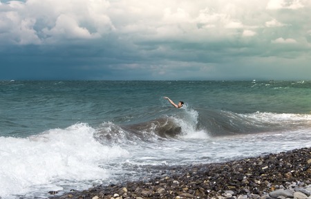 a man swims in the sea with a big wave.の写真素材