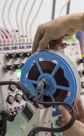 worker corrects the soldering device on the embroidery machine.
