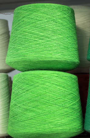 green cotton threads on the coils on the shelf in production.の写真素材