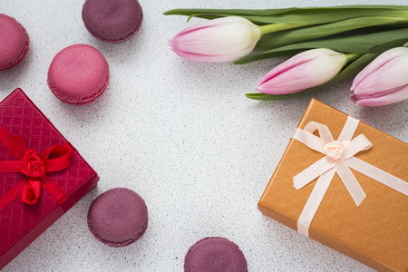 layout of almond cookies with a bouquet of pink tulips and a gift in a box with a copy of space.の写真素材