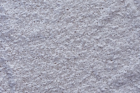 textured background of white knitted fabric top view close-up.の写真素材