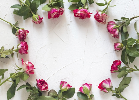 The frame is made of beautiful flowers roses on a white background. Flat position, top view, copy space.の写真素材