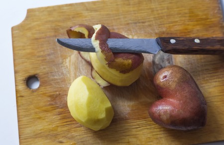 Fresh potatoes in the form of a heart on a cutting Board.の写真素材