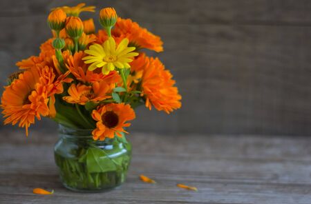 orange bouquet of calendula flowers on wooden background with copy space.の写真素材