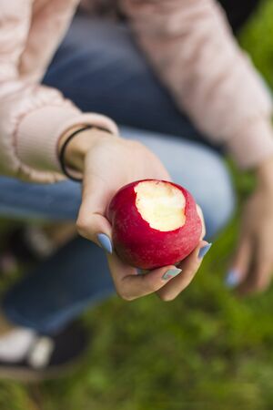 the girl took a bite of a juicy tasty red Apple.