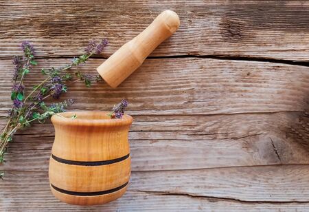 grass thyme with mortar and pestle on wooden background with copy spaceの写真素材