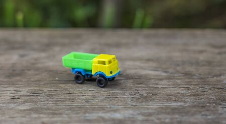 toy truck with yellow cab and green body on wooden backgroundの写真素材