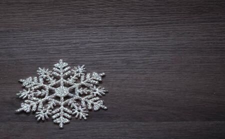 Concept of winter holidays, background of one snowflake on a wooden surface.の写真素材