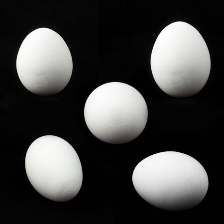 five white chicken eggs on black background.の写真素材