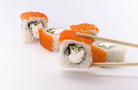 Delicious fresh sushi rolls with salmon and Philadelphia cheese on sticks on a white background.の写真素材