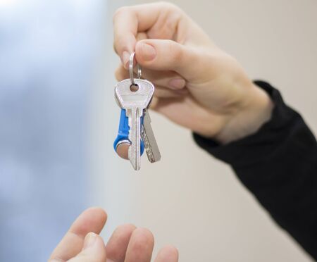 The realtor passes the keys to the apartment to the clients.the concept of selling or renting a...