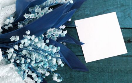 delicate lilies of the valley with a copy of the space on a wooden background Tinted with classic blue.の写真素材