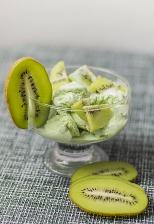 a portion of tender ice cream with slices of fresh kiwi.の写真素材