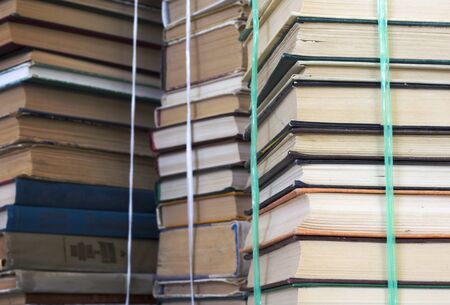stacks of old books in bundles, like a background.の写真素材