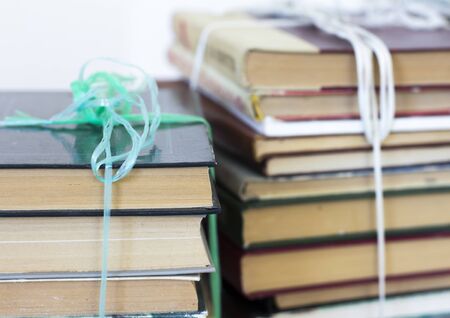stacks of old books tied with string for carrying, close-up.の写真素材