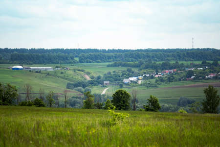 landscape, cloudy sky over a distant Russian green village