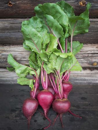 Young fresh beets on a wooden background.