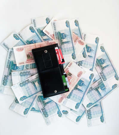 Russian rubles of categories one thousand and five thousand with an open wallet on them, top view.の写真素材