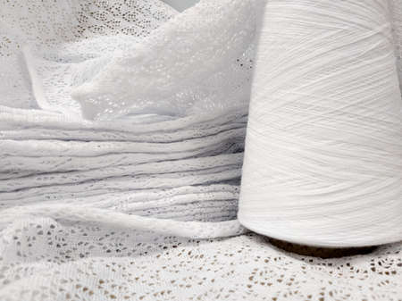 white cotton yarn in bobbins and fabric made from this yarnの写真素材