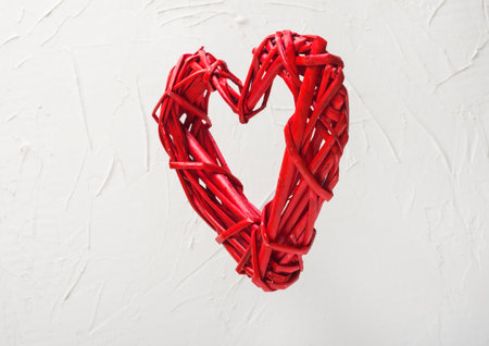 levitation of a braided red heart on a white background valentine's day concept.の写真素材
