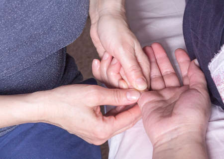 the masseur's hands massage the patient's fingers.の写真素材